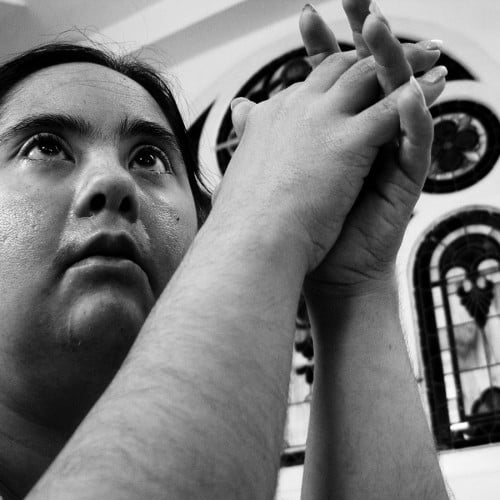 Niña en oracion sindrome de down